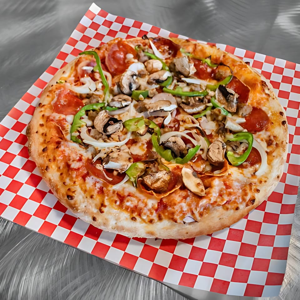 Pizza Time Pub's supreme pizza with pepperoni, mushrooms, onions, and green peppers on checkered paper.