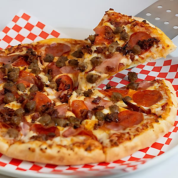A slice of Pizza Time Pub's meat lover's pizza being lifted from the pie with a spatula.